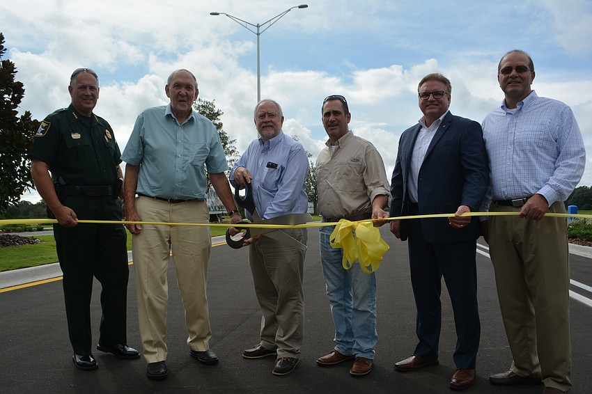 Sheriff Tom Knight, former SMR CEO John Clark, current SMR CEO Rex Jensen, Commissioners Paul Caragiulo and Mike Moran and Administrator Tom Harmer do the honors.