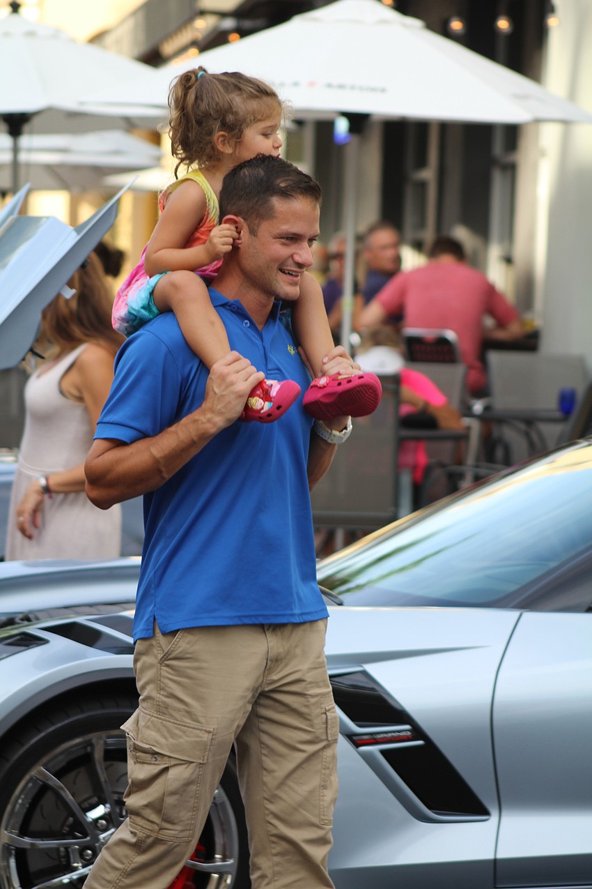 Lakewood Ranch's Soleia and Luke Schefft stroll through the line of cars in Lakewood Ranch.
