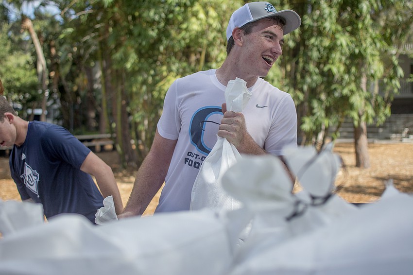 Gus Mahler lifts sandbags at the Out-of-Door Academy's lower school campus on Friday, Sept. 8.