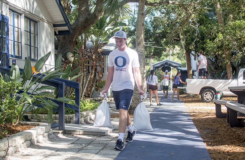 Gus Mahler carries sandbags at Out-of-Door Academy's lower school campus on Sept. 8.