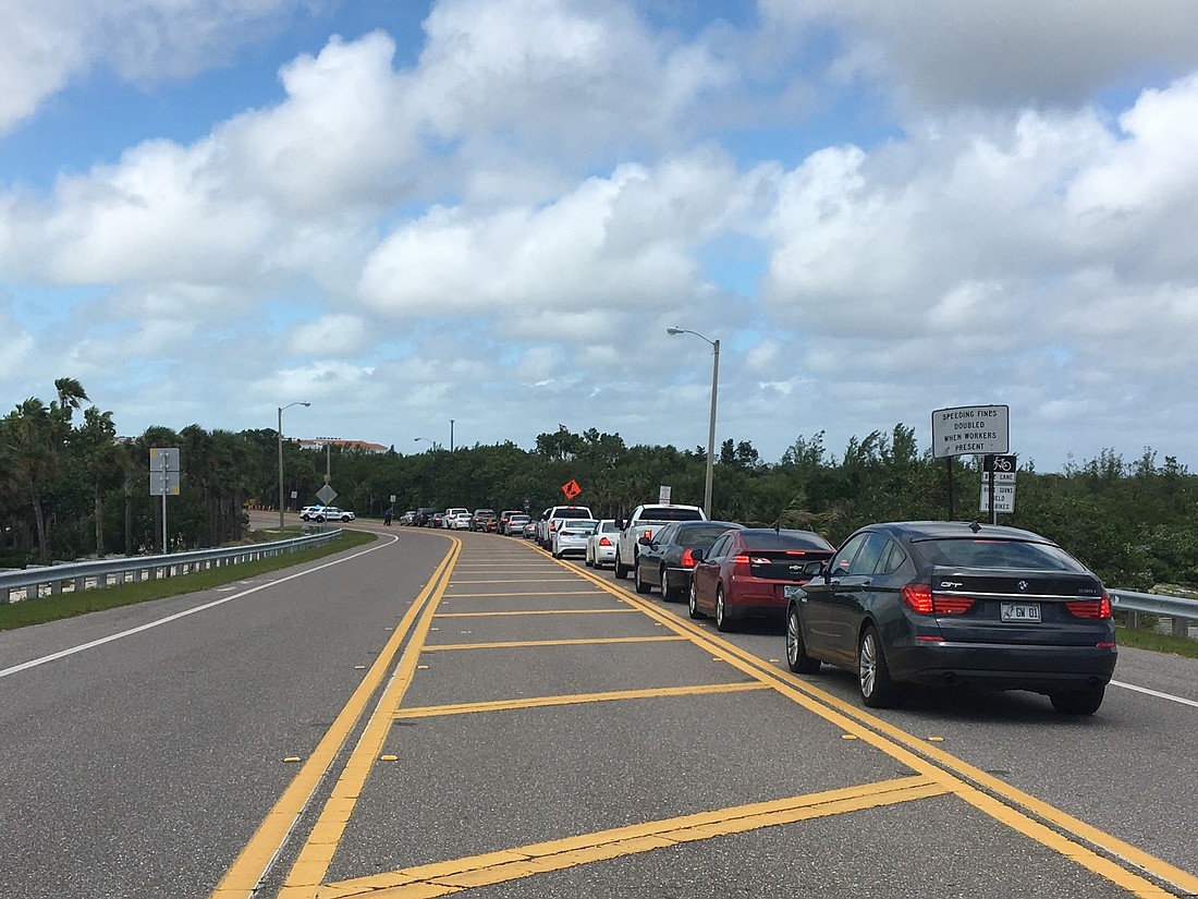 Cars wait in line at a checkpoint to re-enter Longboat Key.