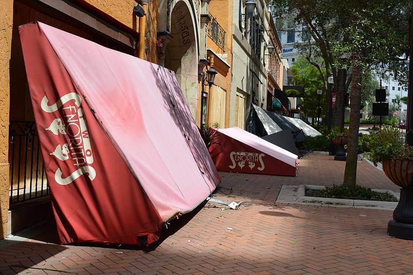 Downed awnings lined the sidewalk on a portion of Main Street Monday afternoon.