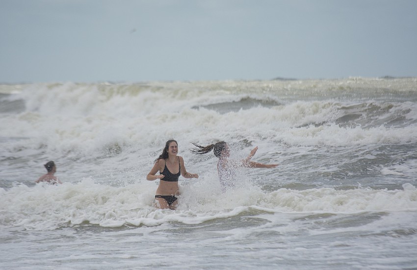 Megan Close, 19, and Lydia Mugford, 21, from Brighton, United Kingdom go for swim shortly after Hurricane Irma passed over Sarasota late Sunday night.