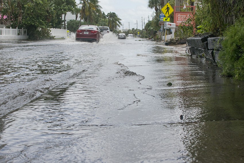 Standing water lapps onto the sidewalk along Ocean Boulevard between Siesta Key Village and Siesta Key Public Beach.