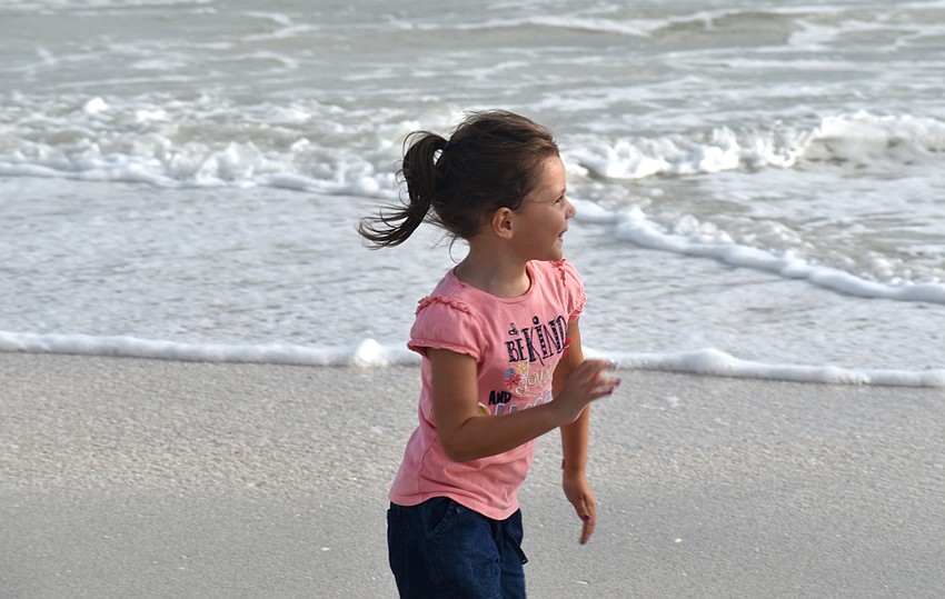Samantha Carmona, 4, laughs as she chases her brother around the shore of Lido Key Beach. Photo by Katie Johns