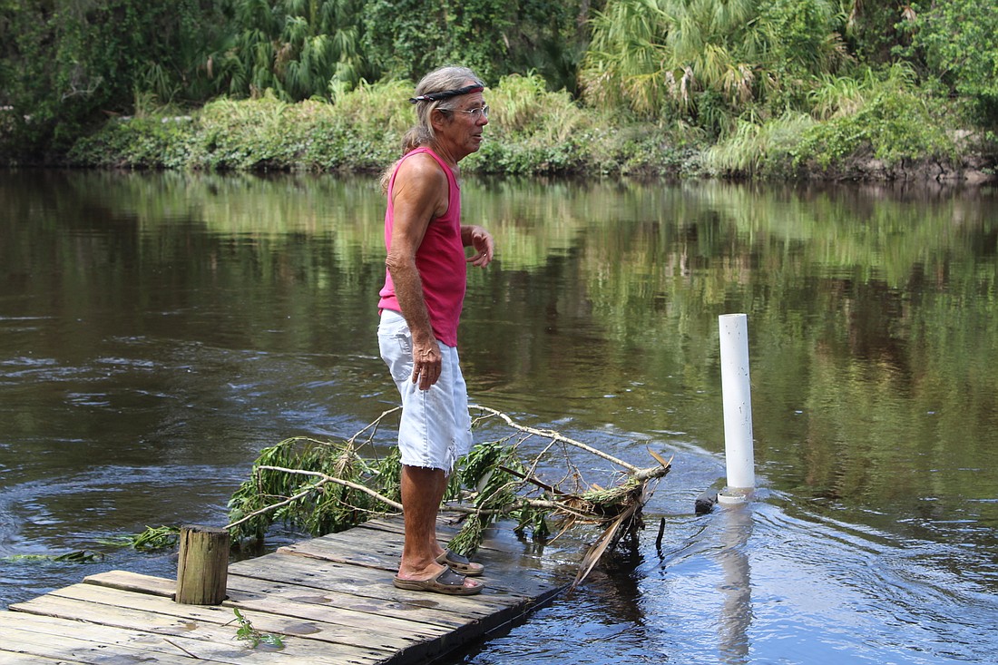 Rayâ€™s Canoe Hideaway Owner Mark Stukey stands on his flooded dock in the Manatee River.
