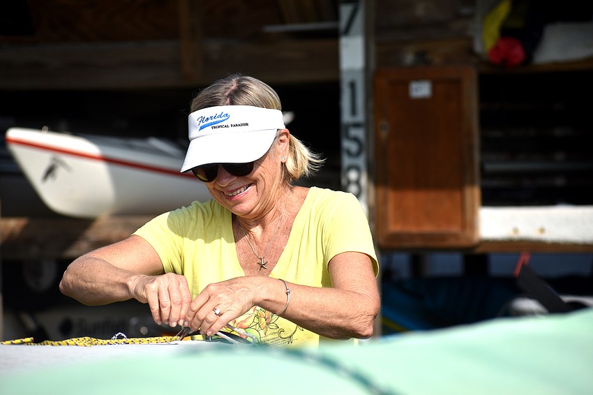Linda Soderlund ties boats back into their spots at the Sarasota Sailing Squadron.