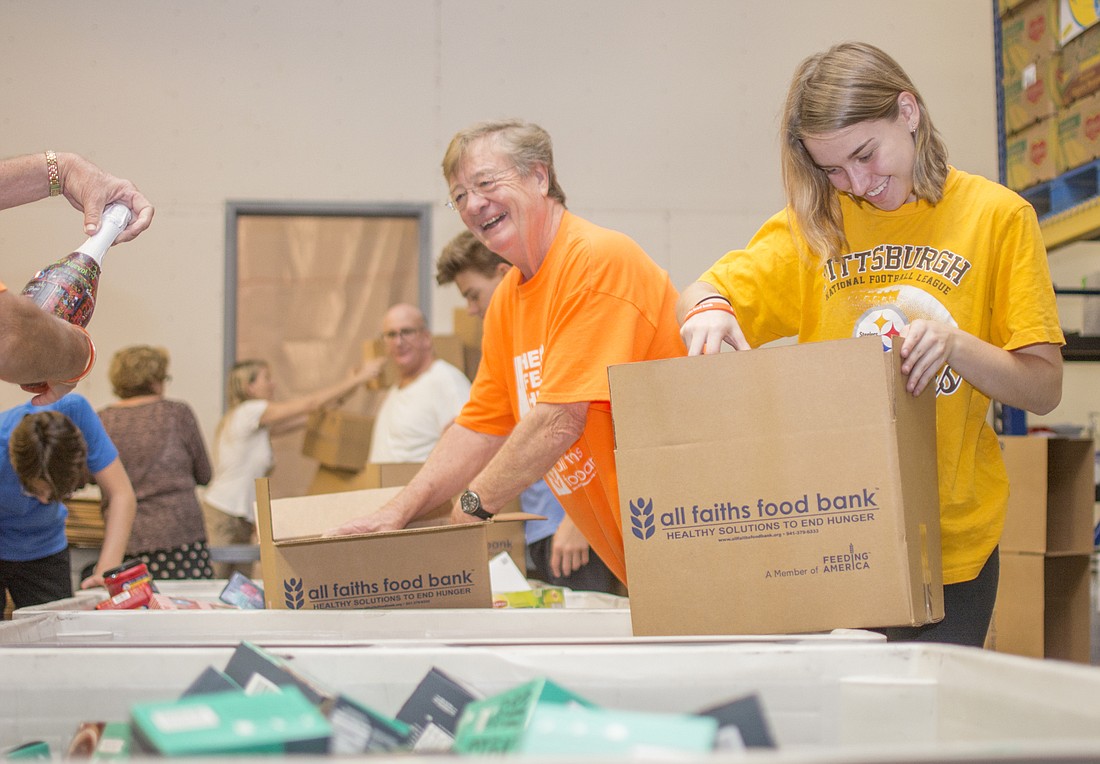 Adrian Lotherington and Natalie Franchini pack emergency boxes at All Faiths Food Bank.