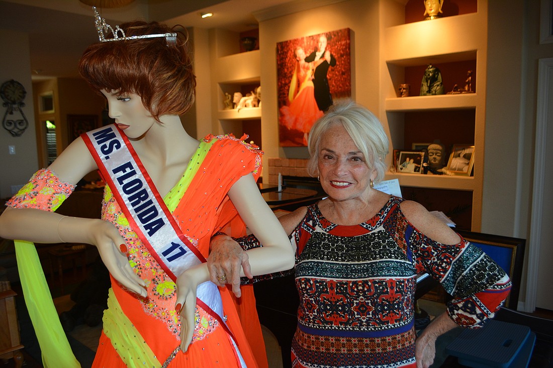 Lorraine Robertson stands by a mannequin at her home she uses to display the gowns she wore ballroom dancing. "They are works of art," she said.
