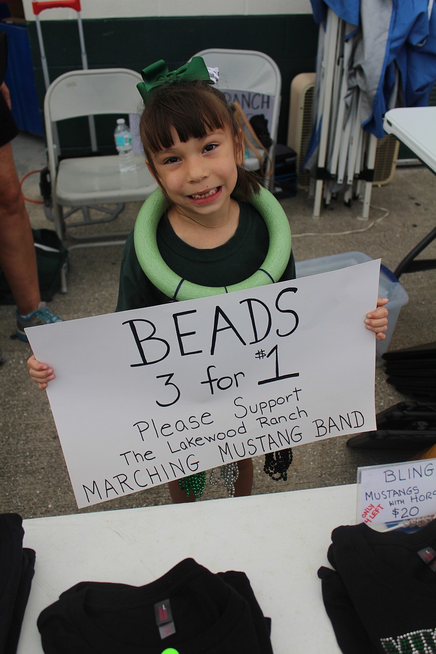 Lakewood Ranch's Laura Staddler sells festive bead necklaces to people at Lakewood Ranch High School's homecoming football game.