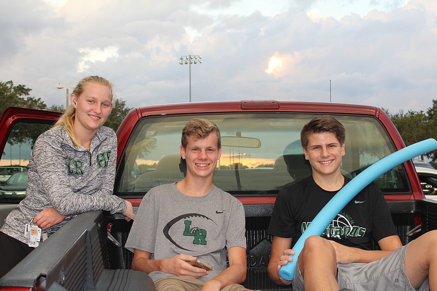 Lakewood Ranch High School students Spencer Mauk, junior, Kennon Moore, freshman, and Andrew den Boggende, sophomore, tailgate in the parking lot before the homecoming game.