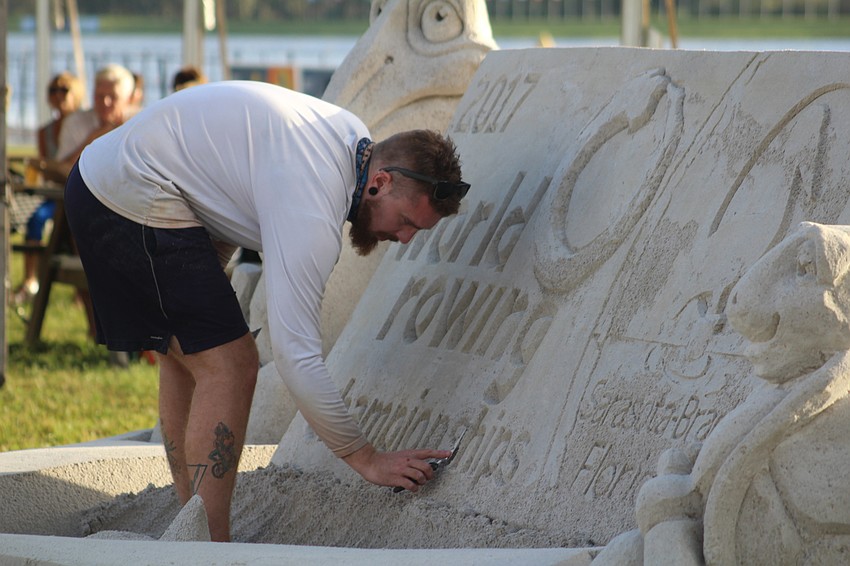 Team Sandtastic's Dean Arscott sand sculpts a sculpture for the 2017 World Rowing Championship.