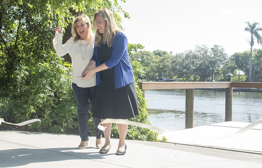 Kimberly Bleach of Bank of America Client Foundation poses with Selby President and CEO Jennifer Rominiecki but the ribbon on the newly improved dock.