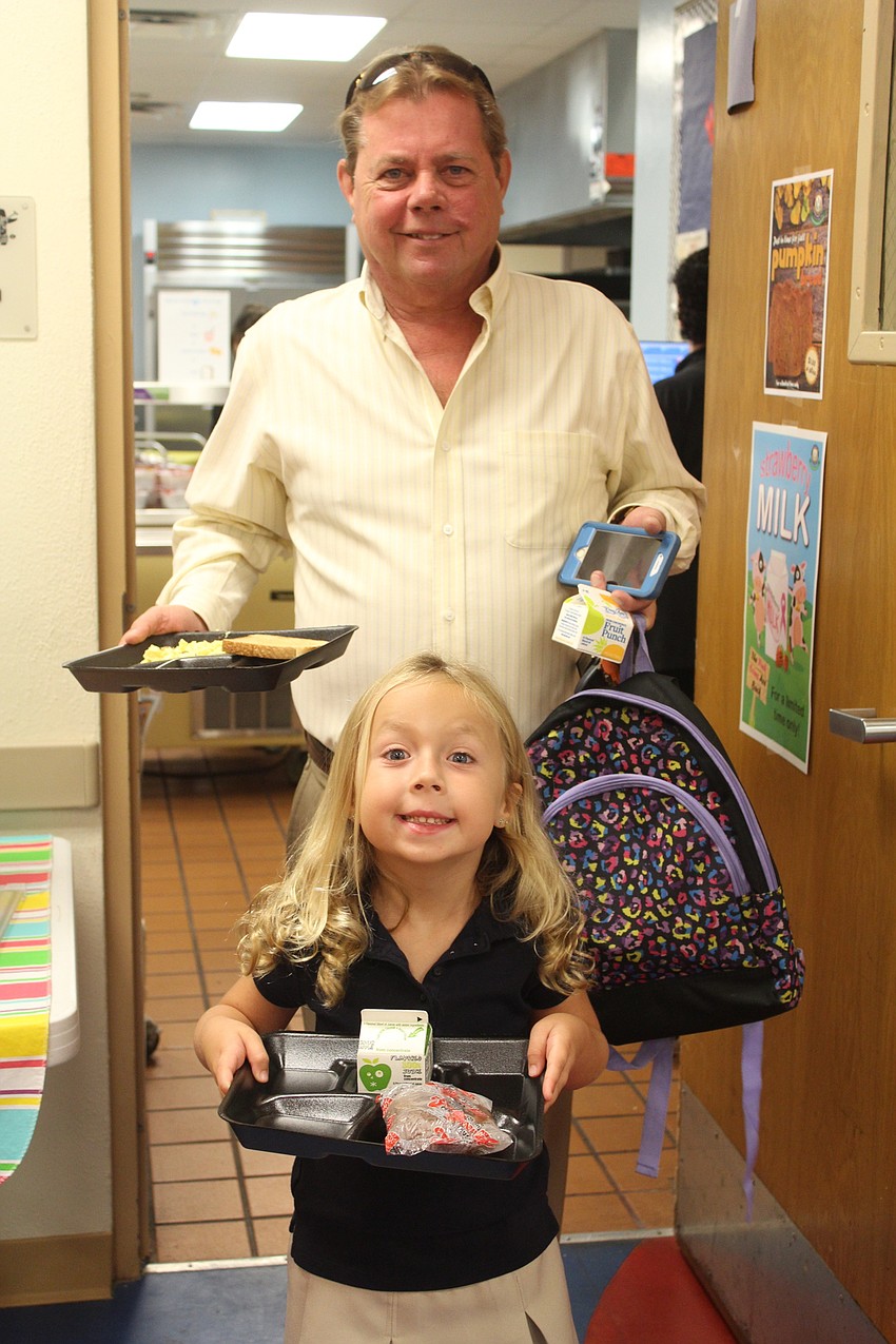 Doug Walkowlak and Braden River Elementary School first-grader Dakota Walkowlak make their way to the VIP section for breakfast.