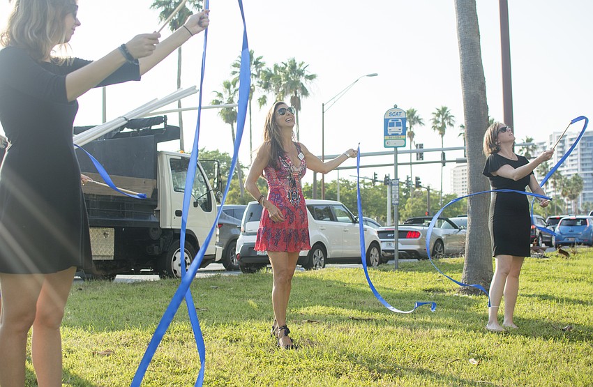 Donna Koffman waves streamers under Betty Schoenbaum's balcony  to celebrate the philanthropist's 100th birthday.