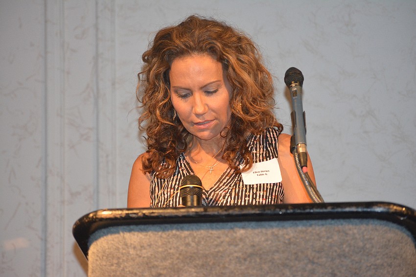 Ellen Drews, wife of event organizer Matt Drews, leads the crowd in prayer.