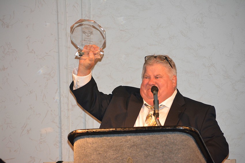 Ron Jones holds up his Hall of Fame award with pride.