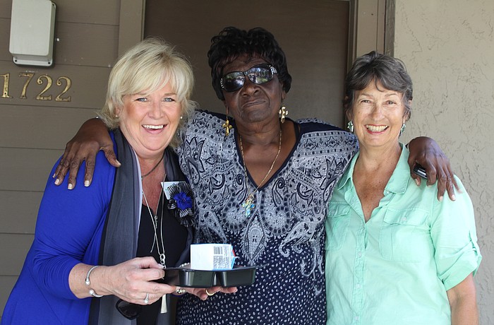 Maribeth Phillips, chief executive officer for Meals on Wheels Plus of Manatee,  Bradentonâ€™s Albertine Francis and Meals on Wheels volunteer Lorraine Kreuzburg meet on a delivery route.