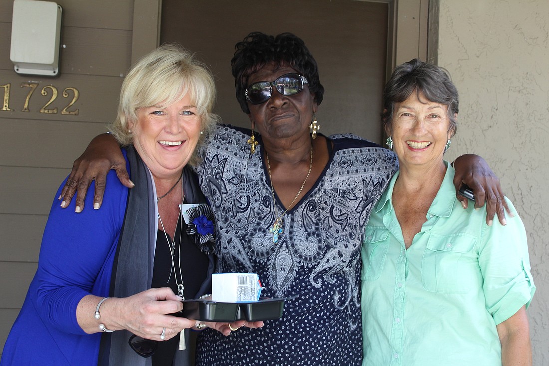 Maribeth Phillips, chief executive officer for Meals on Wheels Plus of Manatee,  Bradentonâ€™s Albertine Francis and Meals on Wheels volunteer Lorraine Kreuzburg meet on a delivery route.