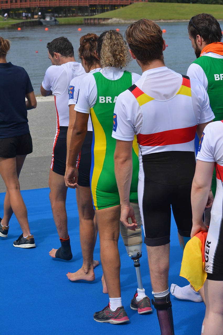 Brazil's Diana Barcelos de Oliveira (in green) walks to the medal stand. She paired with Jairo Klug to win the Para-Rowing Mixed Double Sculls.