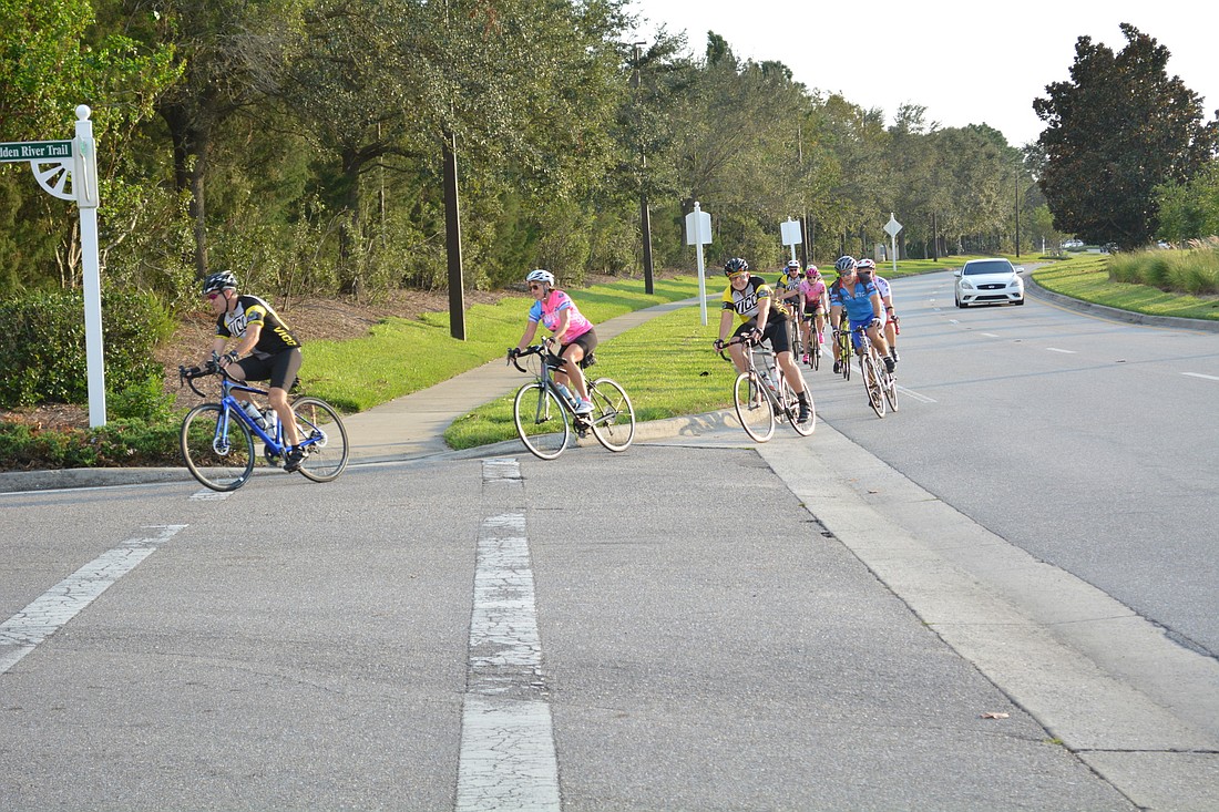 Cyclists in the Lakewood Ranch-based Village Idiots cycling group turn onto  Hidden River Trail from Lakewood Ranch Boulevard to travel to Lorraine Road during a weekly Wednesday night ride.