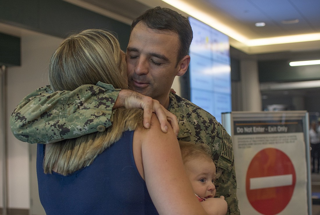 Commander Joe Hembree hugs wife Melissa Hembree in Sarasota-Bradenton International Airport on Sept. 29.