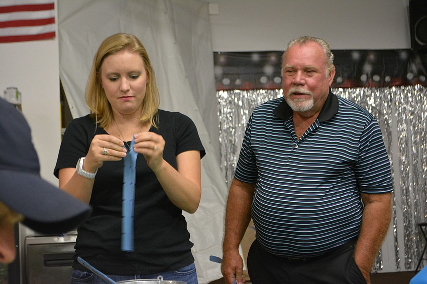 Kayla Cerquozzi gets 50/50 tickets ready while Jerry Ditty digs for dollars.