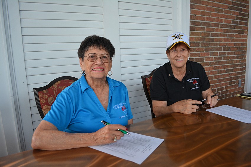 Joanne DiCarlo and Teri Dangel check in golfers before the Elks Golf Tournament.