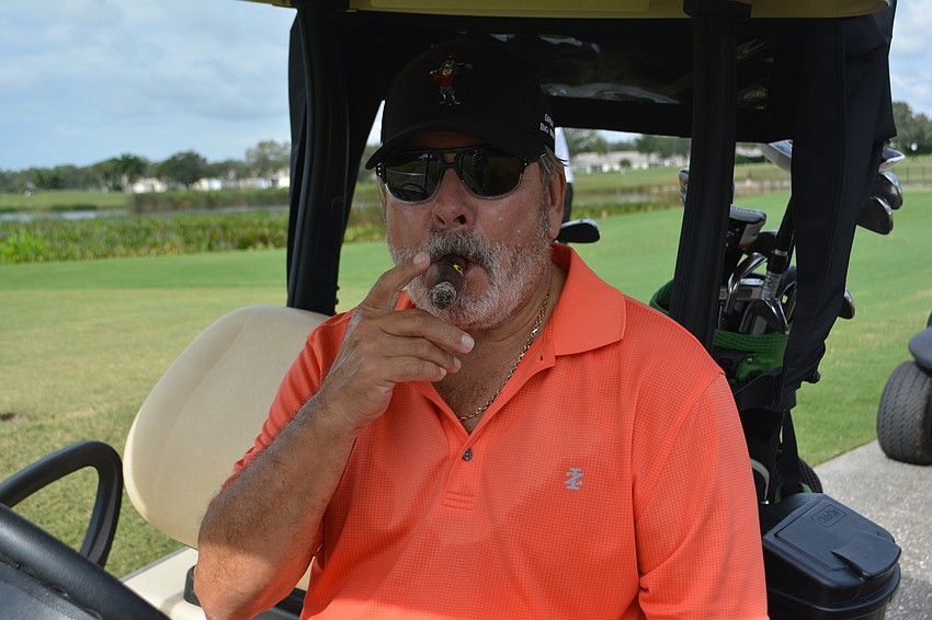 Larry O'Connor enjoys a victory cigar after sinking a birdie putt.