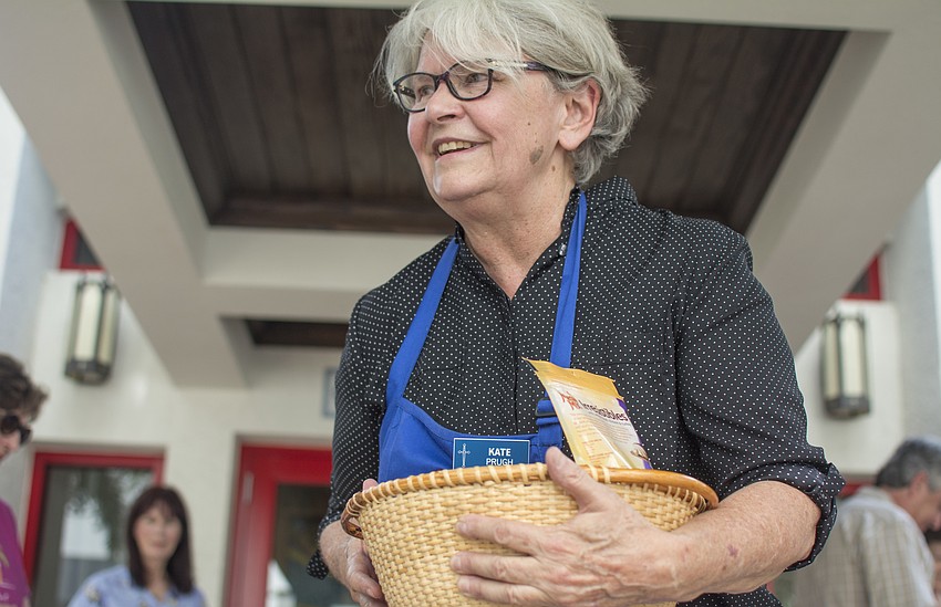 Kate Prugh passes out treats to dogs waiting to receive their blessing at Church of the Redeemer on Oct.1.