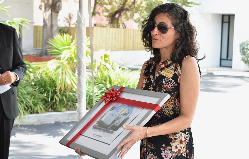 Melody Mora-Shihadeh presents Ronda Montminy and Arnold Simonsen with a print of the theatre wing they donated $1 million to.