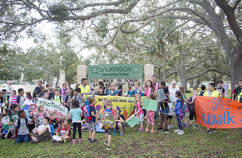 Walkers gathered in front of the Wilkinson Elementary School sign after their walk to school.