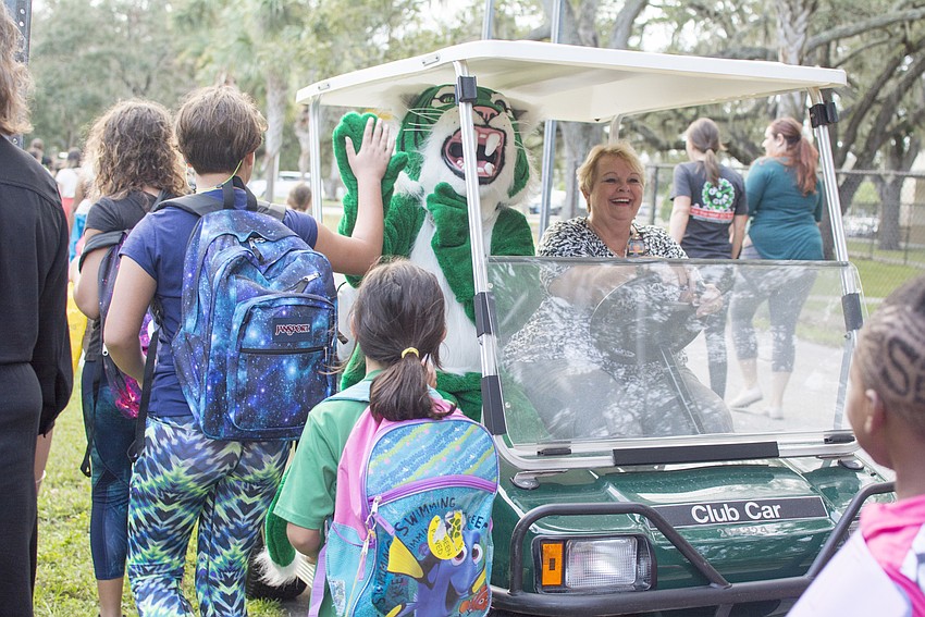 Wilkie the wildcat greets students after their walk to school.