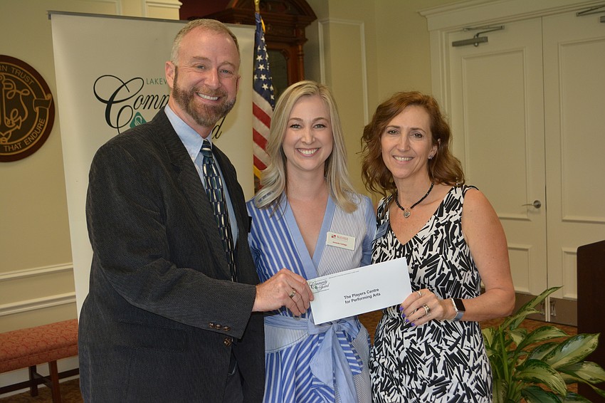 Community Fund advisor Amanda Tullidge (center) presents a check for $10,000 to The Players Centre for Performing Arts' Jeffery Kin and Michelle Bianchi.