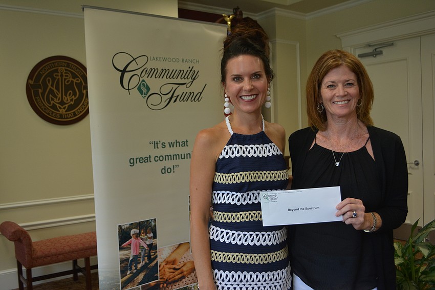 Community Fund advisor Shari Phillips presents a check for $4,400 to Beyond the Spectrum's Catherine Peabody.