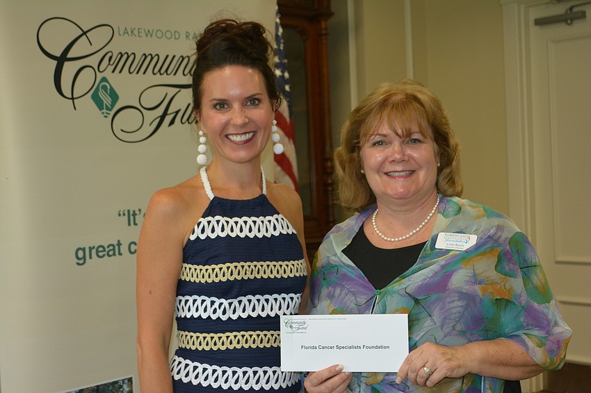 Community Foundation advisor Shari Phillips presents a check for $4,500 to Florida Cancer Specialists' Lynn Rasys.