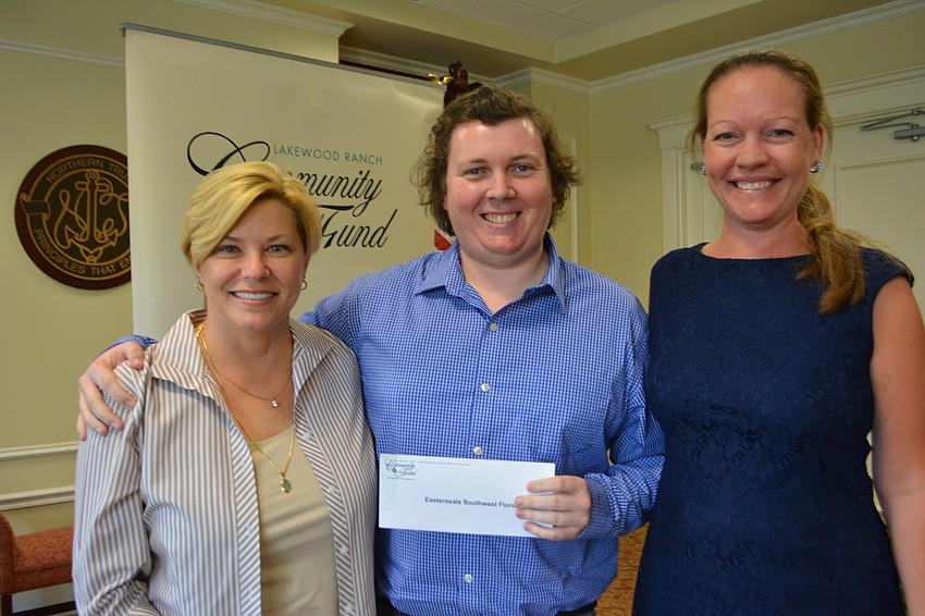 Former Community Fund board member Angela Massaro-Fain presents a check for $5,000 to Easterseals Southwest's Christopher Collins and Nicole Murby.