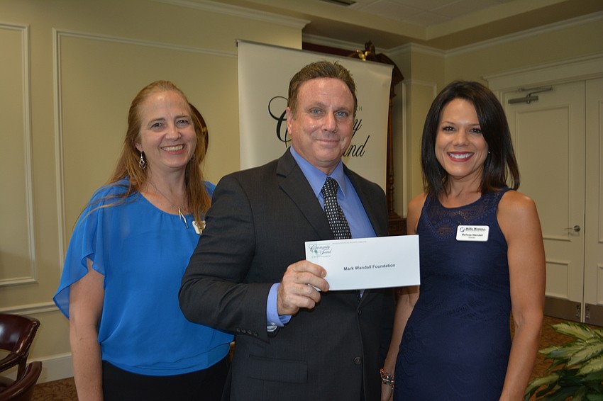 Community Foundation President Chris Romine (center) presents a check for $4,800 to  Wendy Orlando and Melissa Wandall of the Mark Wandall Foundation.