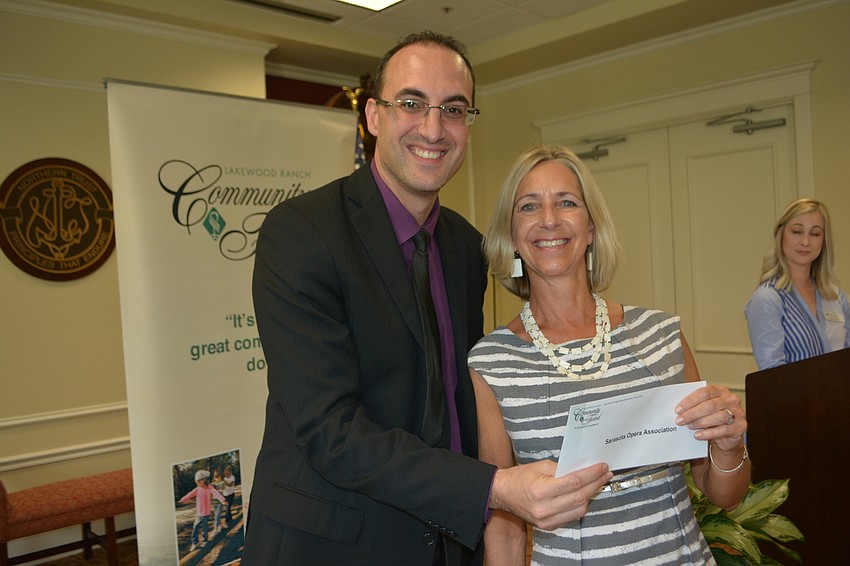 Community Fund board member Darren Haimer presents a check for $5,000 to the Sarasota Opera Association's Stacy Ridenour.