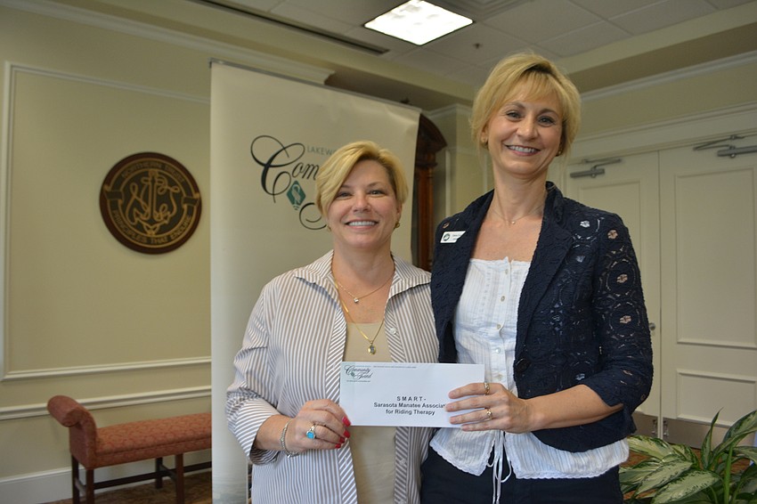 Former Community Foundation board member Angela Massaro-Fain presents a check for $3,000 to SMART's Dana Cornell.