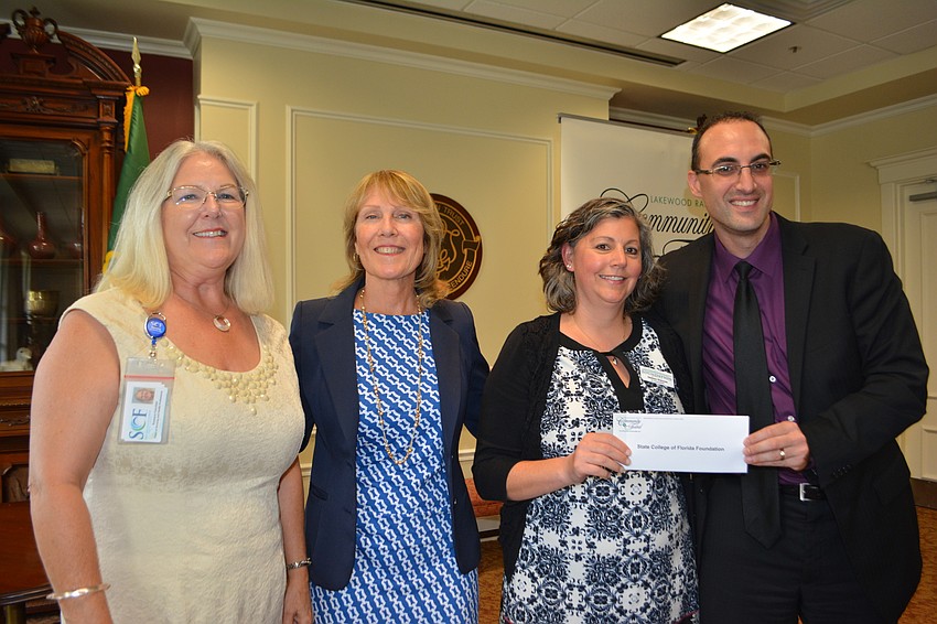 State College of Florida's Rosie Fairchild, Casandra Holmes and Melissa Shippee receive a check for $2,579 from Community Fund board member Darren Haimer.