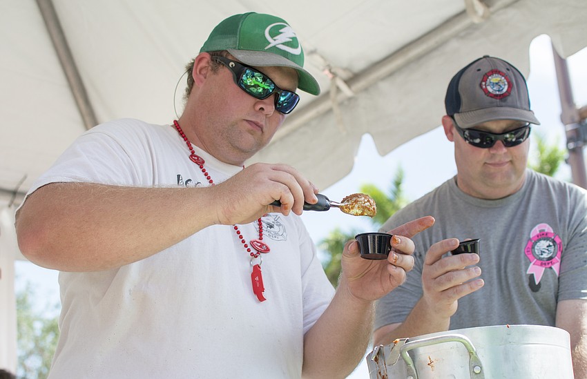 Patrick O'Conner and Damon Williams of Boca Grande Fire Department pour samples during the Morton's 18th Annual Firehouse Chili Cook-off.