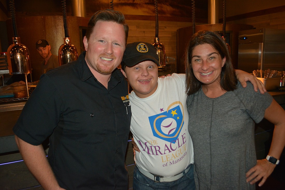 Oak & Stone Assistant General Manager Patrick Goeser visits with The Miracle League&#39;s Andrew Leibin and his mom, Jaycie.