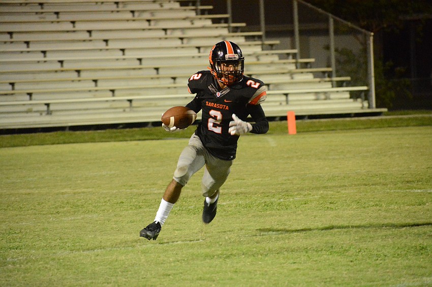 Sarasota senior quarterback Tommie Battie IV scrambles up the right sideline.