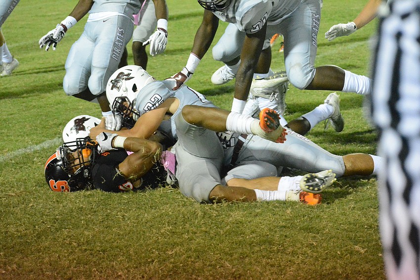 Braden River junior Tyler Navas (22) lays a hit on Sarasota's Brian Battie.