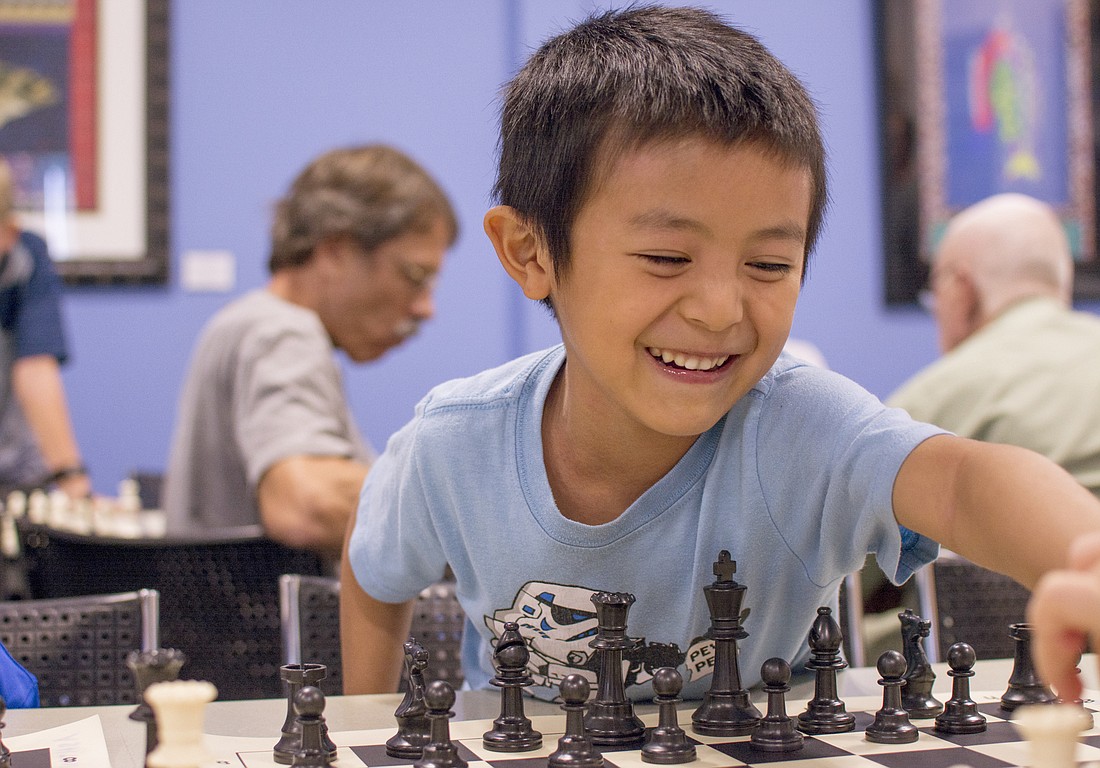 Bryan Song plays with a chess pieces between matches.