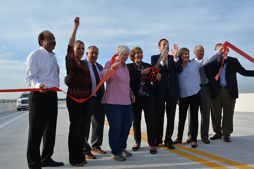 County and state officials cut a ceremonial ribbon to mark the opening of the Fort Hamer Bridge.