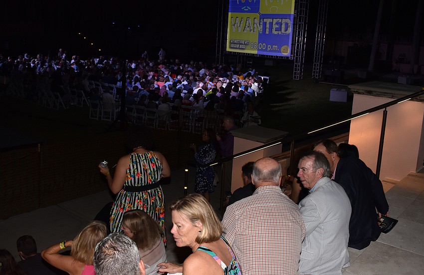 Guests sat on the lawn and on the stairs for the performance of “WANTED” by eVenti Verticali at First Night RIAF 2017 on Oct. 18 at The Ringling.