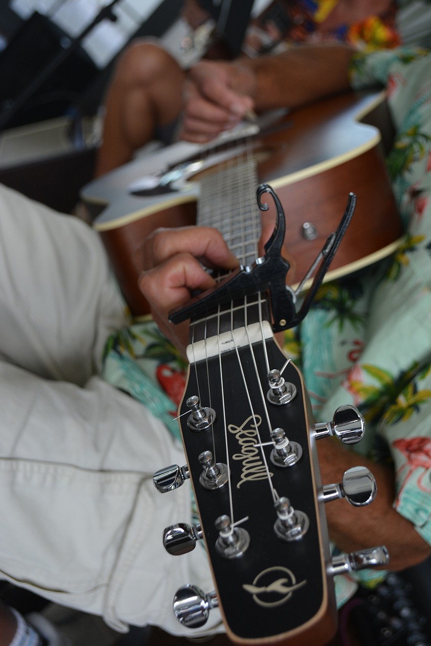 Tom Perillo plays his acoustic guitar during a practice session. He and Irvan play acoustic guitars while Combs played an electric guitar.