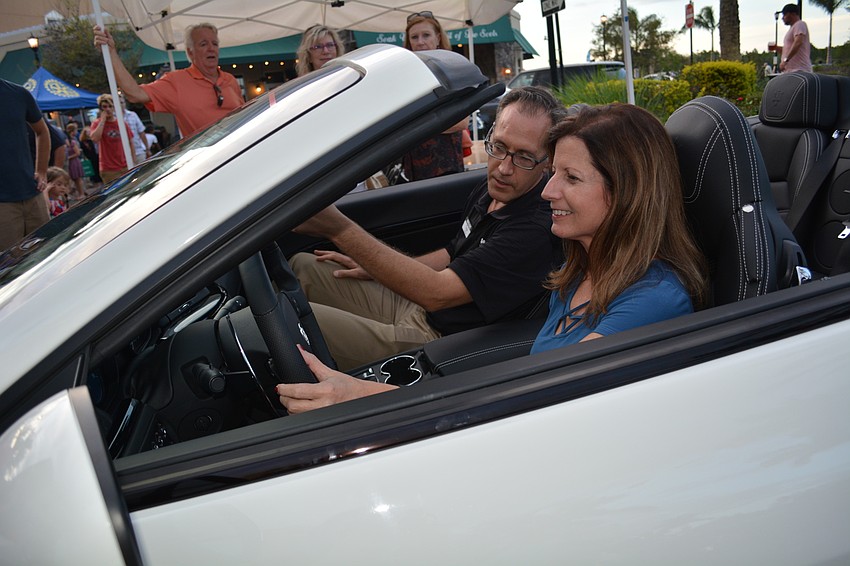 Wilde Maserati Sarasota's Brenda Holmes, front, and Taga Sickler, behind, rev up the engine of this convertible, which attracted a crowd.
